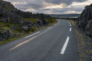 Narrow road through the rugged landscape. Road to Hamninberg. Varanger Peninsula, Norway