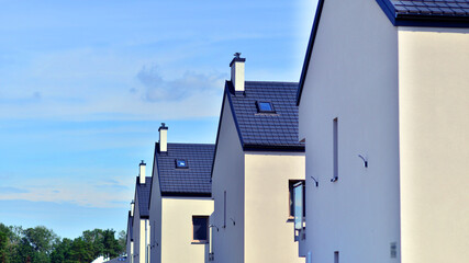 Terraced residential homes with modern facade in newly developed housing estate. The real estate market in the suburbs. New terraced houses in a new development area.