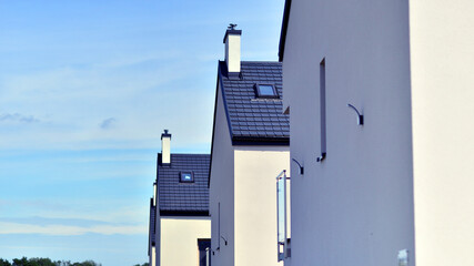 Terraced residential homes with modern facade in newly developed housing estate. The real estate market in the suburbs. New terraced houses in a new development area.