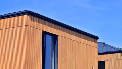 Residential homes with modern wood facade. Terraced family homes in newly developed housing estate....