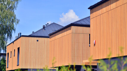 Residential homes with modern wood facade. Terraced family homes in newly developed housing estate....