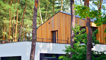 Upscale house in wooded area. Fragment of a single-family house facade. 