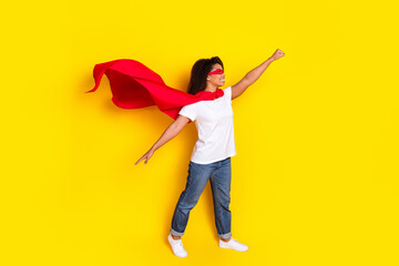 Full length portrait of nice young woman superhero costume isolated on yellow color background