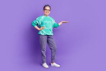 Full body photo of attractive senior woman show measure empty space dressed stylish green clothes isolated on purple color background