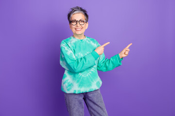 Photo portrait of lovely pensioner lady point empty space dressed stylish green garment isolated on purple color background