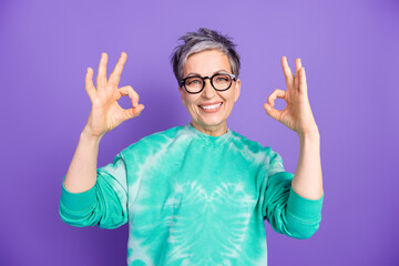 Photo portrait of lovely pensioner lady show okey approve dressed stylish green garment isolated on purple color background