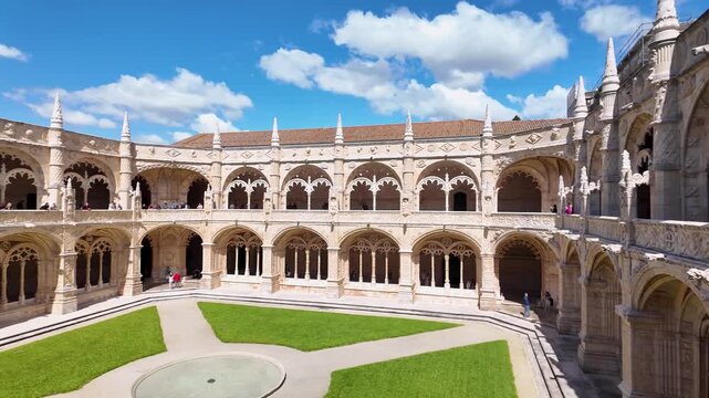 Courtyard and cloisters of the Jer&oacute;nimos Monastery, Mosteiro dos Jeronimos in the Belem district. The church dome in the background. Lisbon, Portugal.