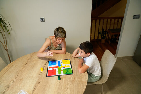Mother and son intently focused on a board game move