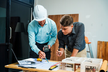 A Caucasian male engineer and an Italian male building contractor are planning and talking at a...