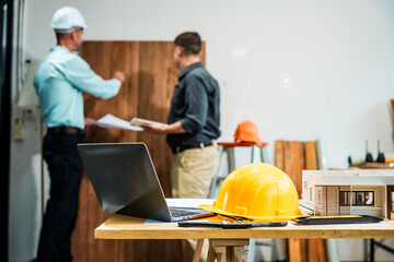 A Caucasian male engineer and an Italian male building contractor are planning and talking at a...