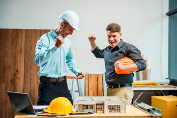 A Caucasian male engineer and an Italian male building contractor are planning and talking at a...