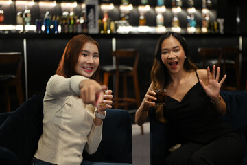 Two joyful women having a great time at a cozy bar. Nightlife, celebrations and friendship concept