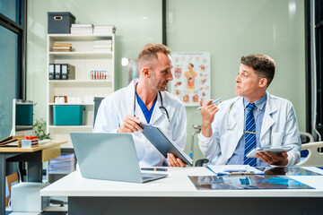 In a hospital meeting room,Italian male and Caucasian male discuss medical cases at desk with X-ray films, blood samples, patient information, on diagnosing heart disease and treatment guidelines.