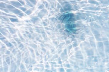 Blue water with ripples on the surface. Defocus blurred transparent blue colored clear calm water surface texture with splashes and bubbles. Water waves with shining pattern texture background.