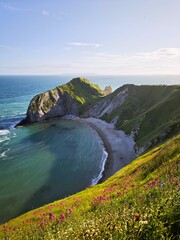 Capture the breathtaking beauty of Durdle Door and Man O'War Beach on the Jurassic Coast, UK. This stunning view showcases the iconic limestone arch, coastal cliffs, and serene beachscape.