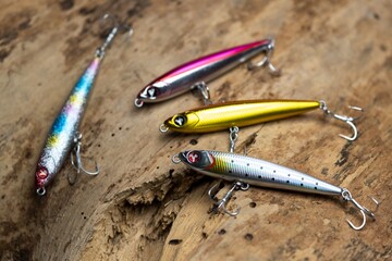 A set of colorful fishing lures arranged on a black reflective surface.