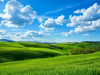 Obraz premium Lush, green hills under a bright, blue sky with puffy, white clouds