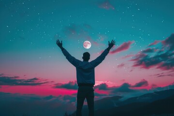 Fototapeta premium Man with his arms raised in the sky blue and pink sunset sky with mountains on top of it. 