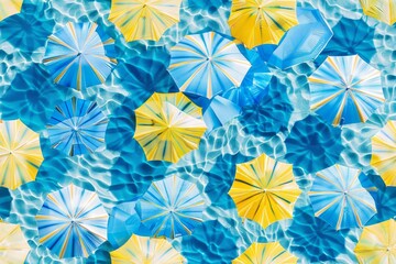 Modern blue and yellow beach umbrellas with stripes on a sand beach, top view seamless pattern