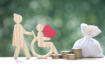 Employee volunteer assistant with man on wheelchair and money bag on natural green background,Save money for prepare in future and handicapped person concept