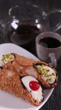 Cannoli Siciliani sul piatto, tazzina di caff&egrave; caldo fumante e caraffa 