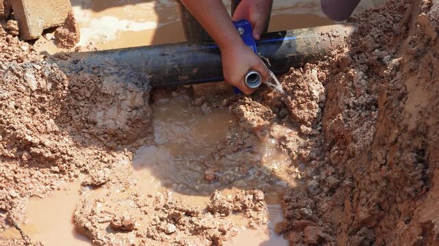 Clean water main pipe on the street, additional fitting is broken or burst and leaking water.  It is being repaired by a professional team.