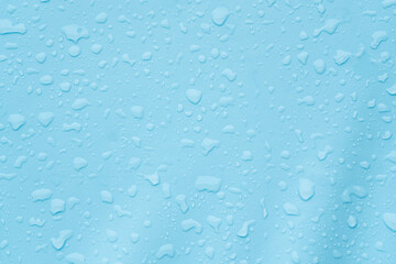 Water droplets on blue surface create textured background, giving a serene and refreshing vibe
