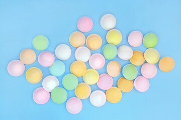 Flying saucer sherbet sweet treat food on blue background. Abstract multicolored design of old fashioned fizzy candy confectionery. © marilyn barbone