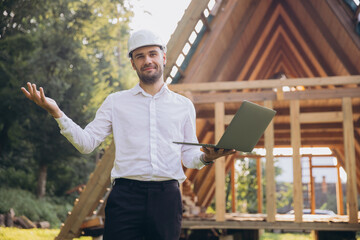 Man builder. Foreman with laptop. Contractor for construction company. Architect in unfinished...