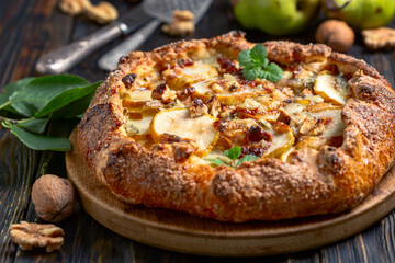 Homemade open pie (galette) with pears, blue cheese and walnuts.