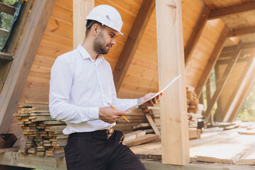 Construction engineer in white helmet. Developer with construction documentation on the background...