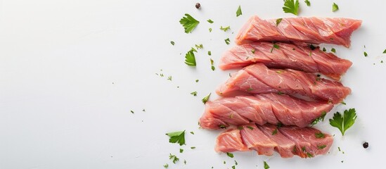 Close up photograph of raw veal strips for preparing Swiss zurcher geschnetzeltes with herbs on a white backdrop emphasizing the copy space image
