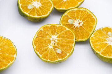 Orange fruit texture with seed placed on white background. Half-orange fruit with concept of fresh and healthy food, cooking, and cutting. Citrus fruit for smoothie. Close-up tangerine orange and seed