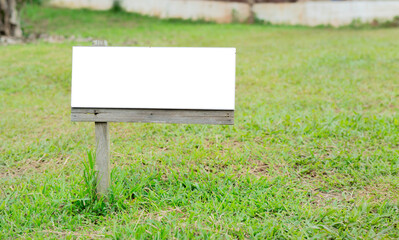 White sing on the background of the lawn. A blank older white board label on the grass.