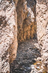 Stream of fresh mountain water flows in narrow gorge in rocks in Tien Shan mountains in Pamir, landscape with rocks for background