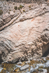 Texture of stone rocks of rock in Tien Shan mountains in Pamir, stream flows between rocks, landscape with rocks for background