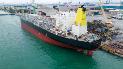 Oil tanker ship at dry dock concept maintenance service. working at dry dock. Insurance and Maintenance Crude tanker Ship concept. Freight Forwarding Service maintenance Insurance