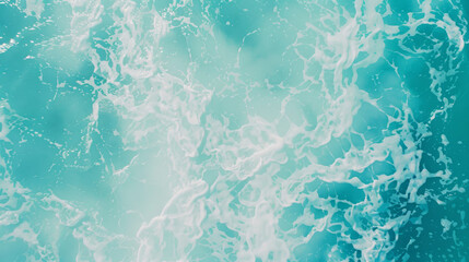 Fototapeta premium An aerial view of foamy ocean waves in dazzling turquoise water.