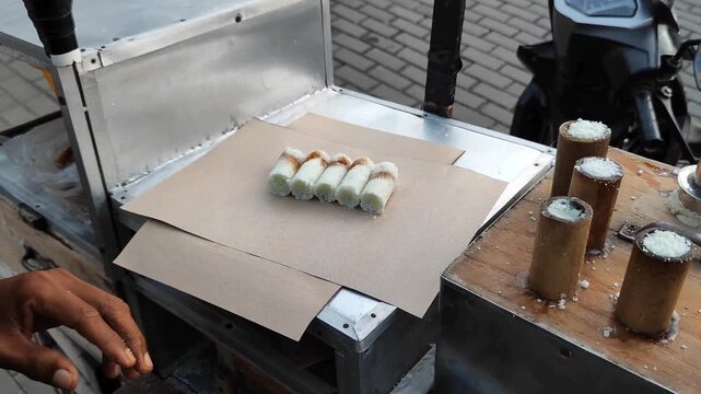 A man serves Putu cake (Bamboo putu)