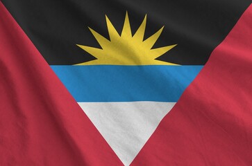 Antigua and Barbuda flag depicted on folded wavy fabric of old cloth close up