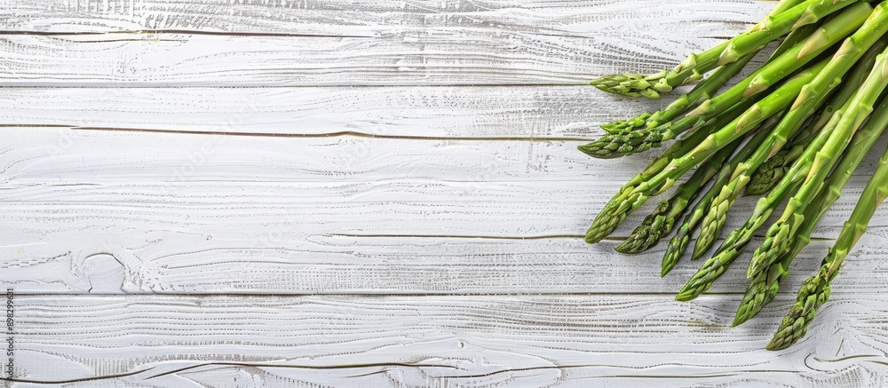 Leinwandbilder close up top view photo of a bunch of fresh asparagus on a white and grey wooden background with emp