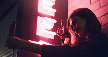 Woman, smile and peace sign for outdoor selfie at night with neon light, digital storage and photo...