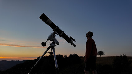 Amateur astronomer looking at the evening skies, observing planets, stars, Moon and other celestial...