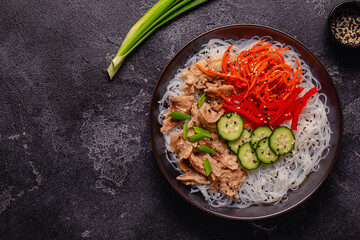 Bowl of rice noodles with vegan soy meat and vegetables.