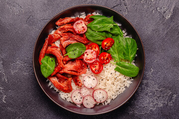 Bowl with vegan fried soy meat and vegetables served with boiled rice.
