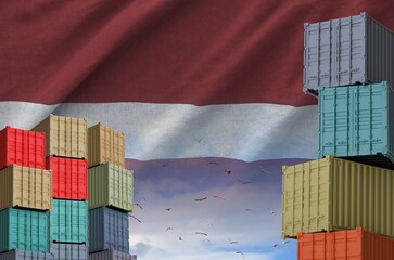Latvia flag and big stack of shipping cargo containers in docks with sky background close up