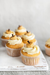 Pumpkin cupcakes with cheesecake frosting on board for Thanksgiving vertical image