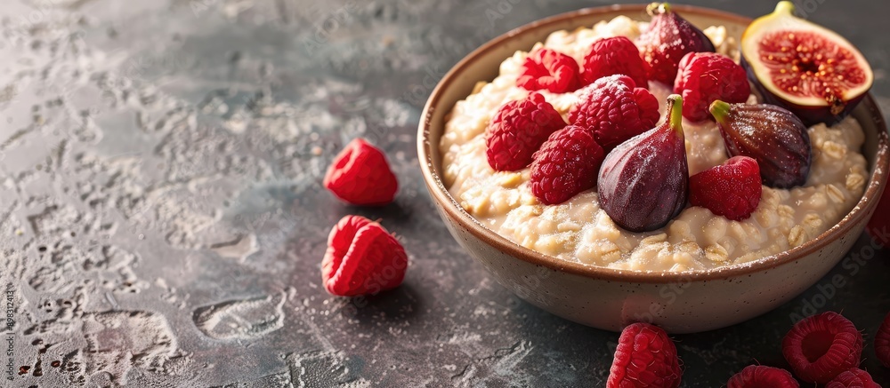 Poster a bowl with oatmeal porridge topped with fresh raspberries and figs set against a plain background f