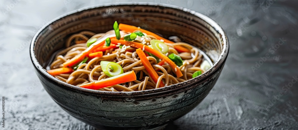 Aufkleber Close up of a bowl of soba noodles with carrots and scallions on a black background suitable for adding text with copy space image