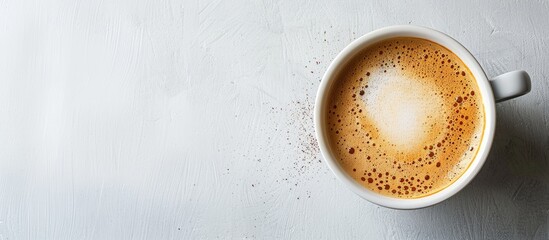 Close up top view of a white coffee cup with a foam fondue perfect for cappuccino or latte against a copy space image